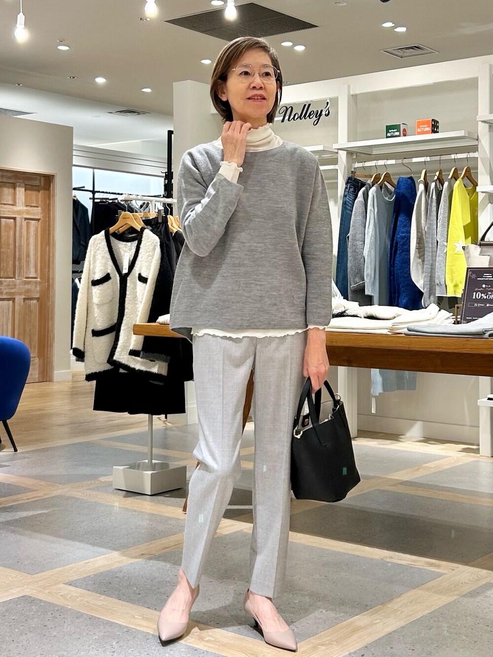 グレー系のその他パンツ、ブラック系のトートバッグ、グレー系のニット/セーターを着用したレディースの秋コーディネートの3枚目の写真