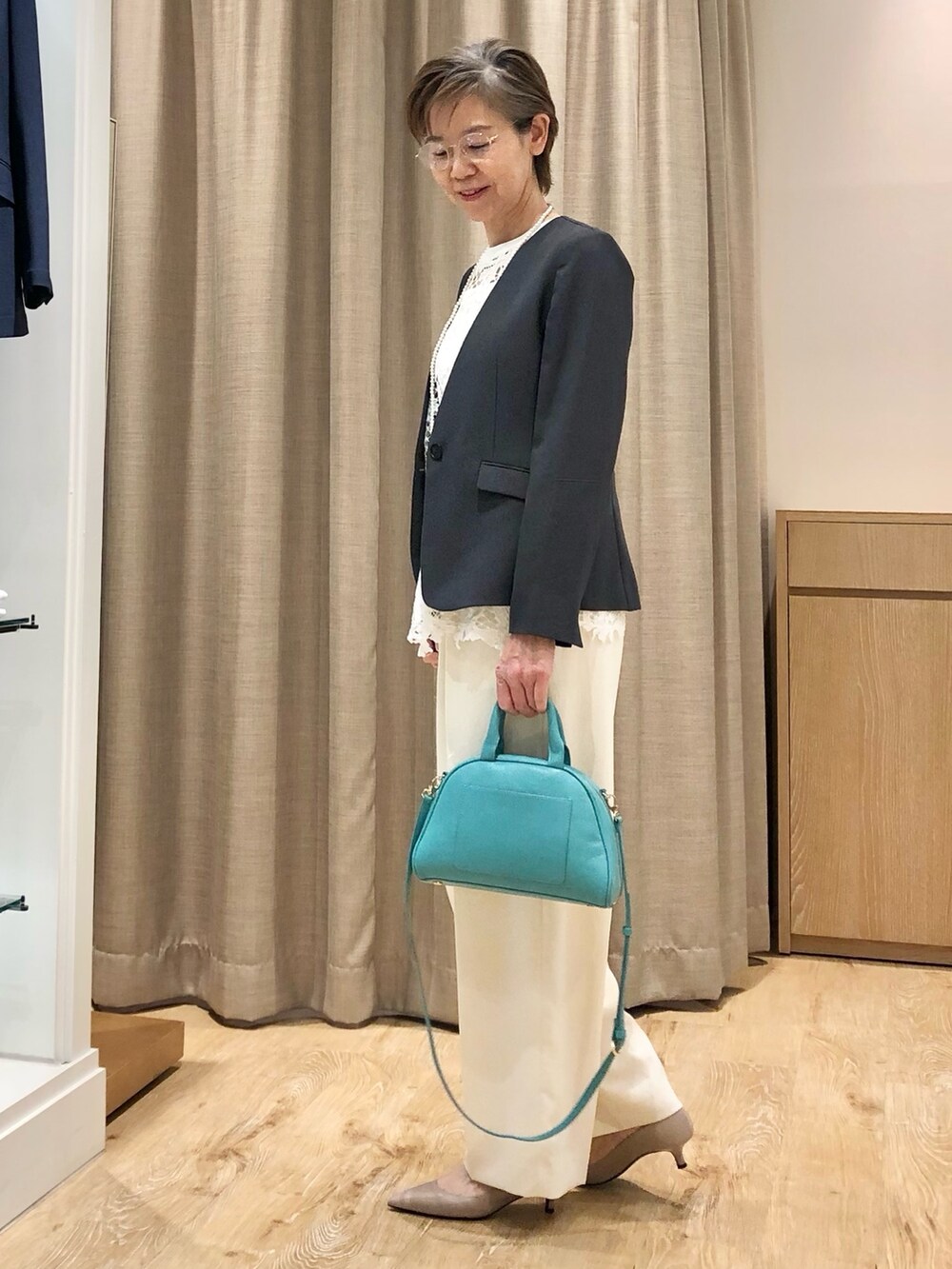 ホワイト系のその他パンツ、グリーン系のボストンバッグ、ホワイト系のシャツ/ブラウスを着用したレディースの夏コーディネートの3枚目の写真