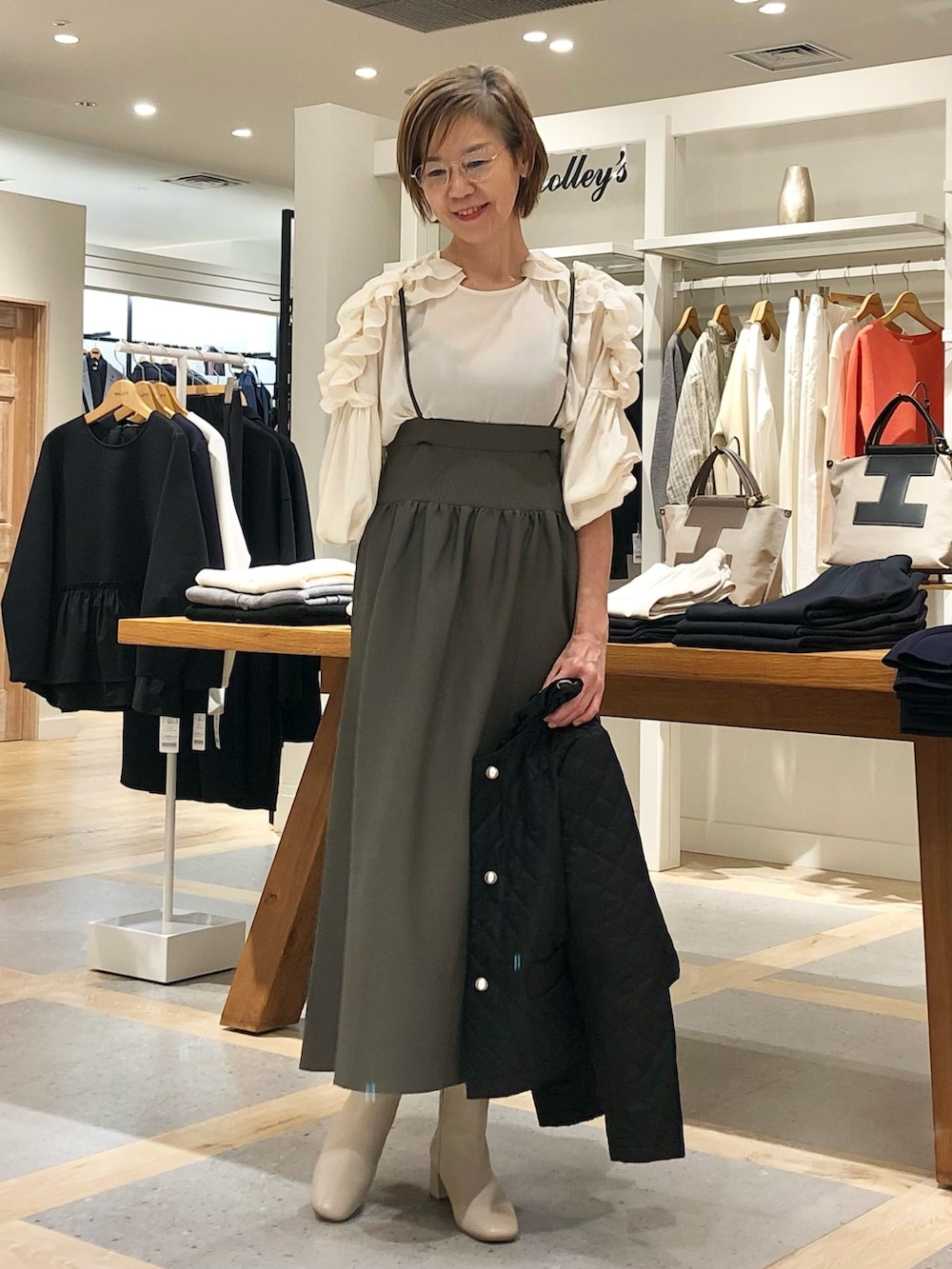 ホワイト系のシャツ/ブラウス、グレー系のスカート、ブラック系のブルゾンを着用したレディースの秋コーディネートの4枚目の写真