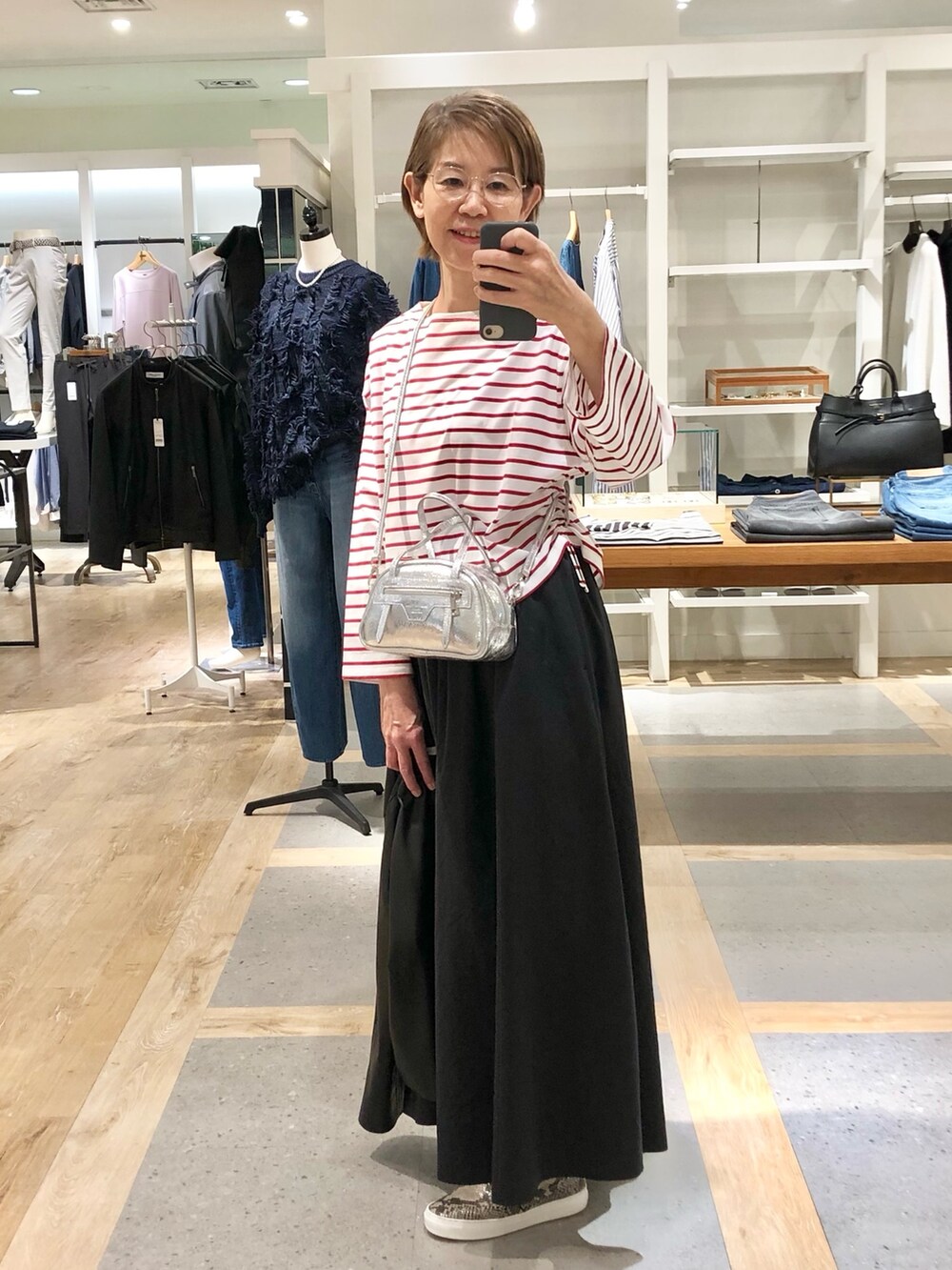 ブラック系のスカート、ブラック系のブルゾン、ホワイト系のTシャツ/カットソーを着用したレディースの秋コーディネートの4枚目の写真