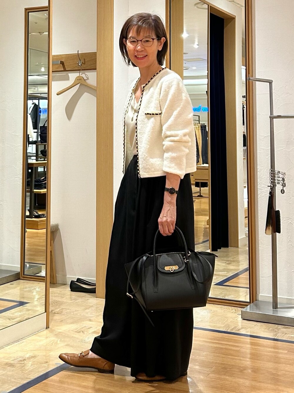 ブラック系のその他パンツ、ブラック系のショルダーバッグ、ホワイト系のカーディガン/ボレロを着用したレディースの秋コーディネートの4枚目の写真