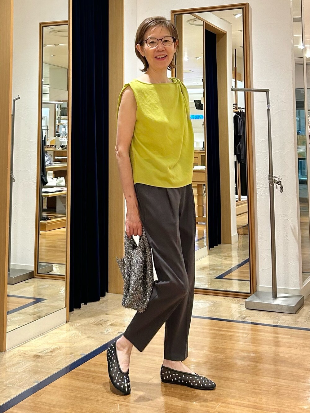 グレー系のその他パンツ、イエロー系のシャツ/ブラウス、ブラック系のバックパック/リュックを着用したレディースの夏コーディネートの2枚目の写真