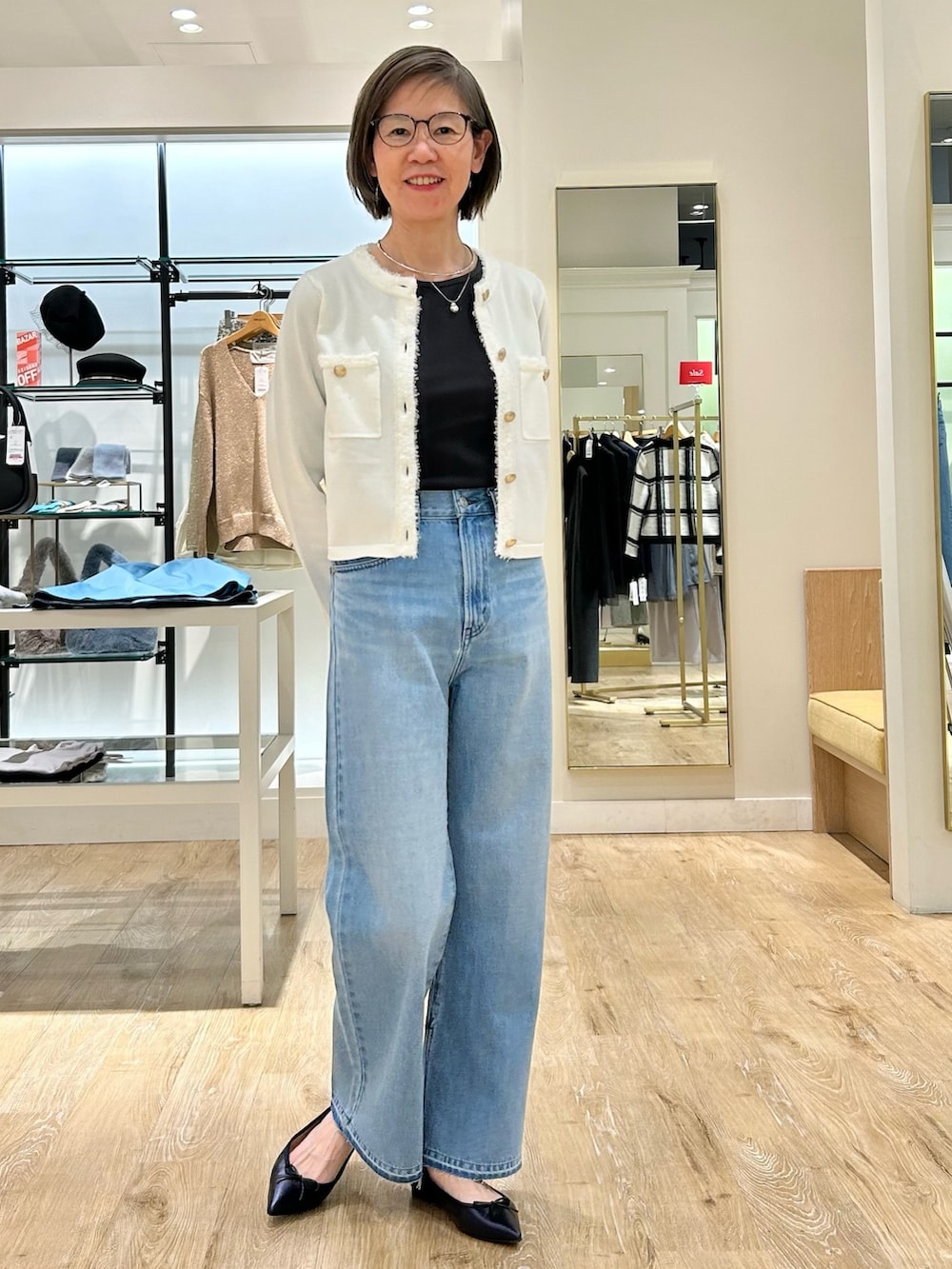 ブルー系のデニムパンツ、ホワイト系のカーディガン/ボレロ、グレー系のTシャツ/カットソーを着用したレディースの冬コーディネートの4枚目の写真