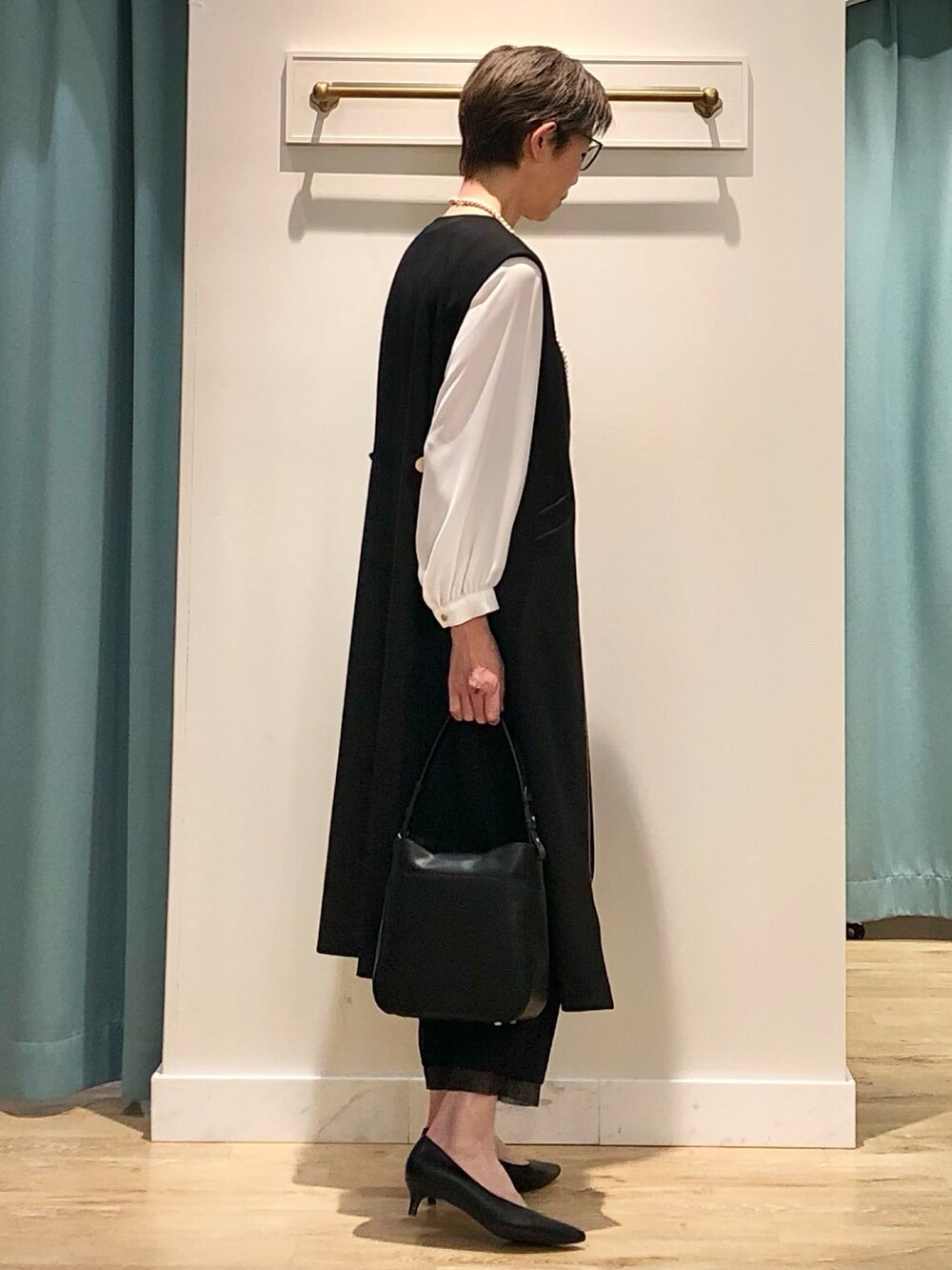 ブラック系のワンピース、ホワイト系のシャツ/ブラウス、ブラック系のその他パンツを着用したレディースの冬コーディネートの4枚目の写真