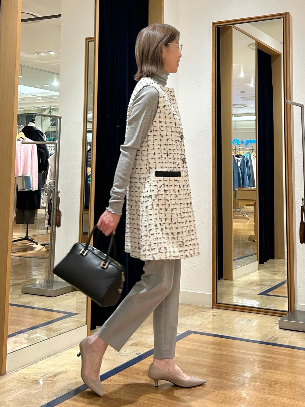 ホワイト系のワンピース、ブラック系のショルダーバッグ、グレー系のその他パンツを着用したレディースの冬コーディネートの4枚目の写真