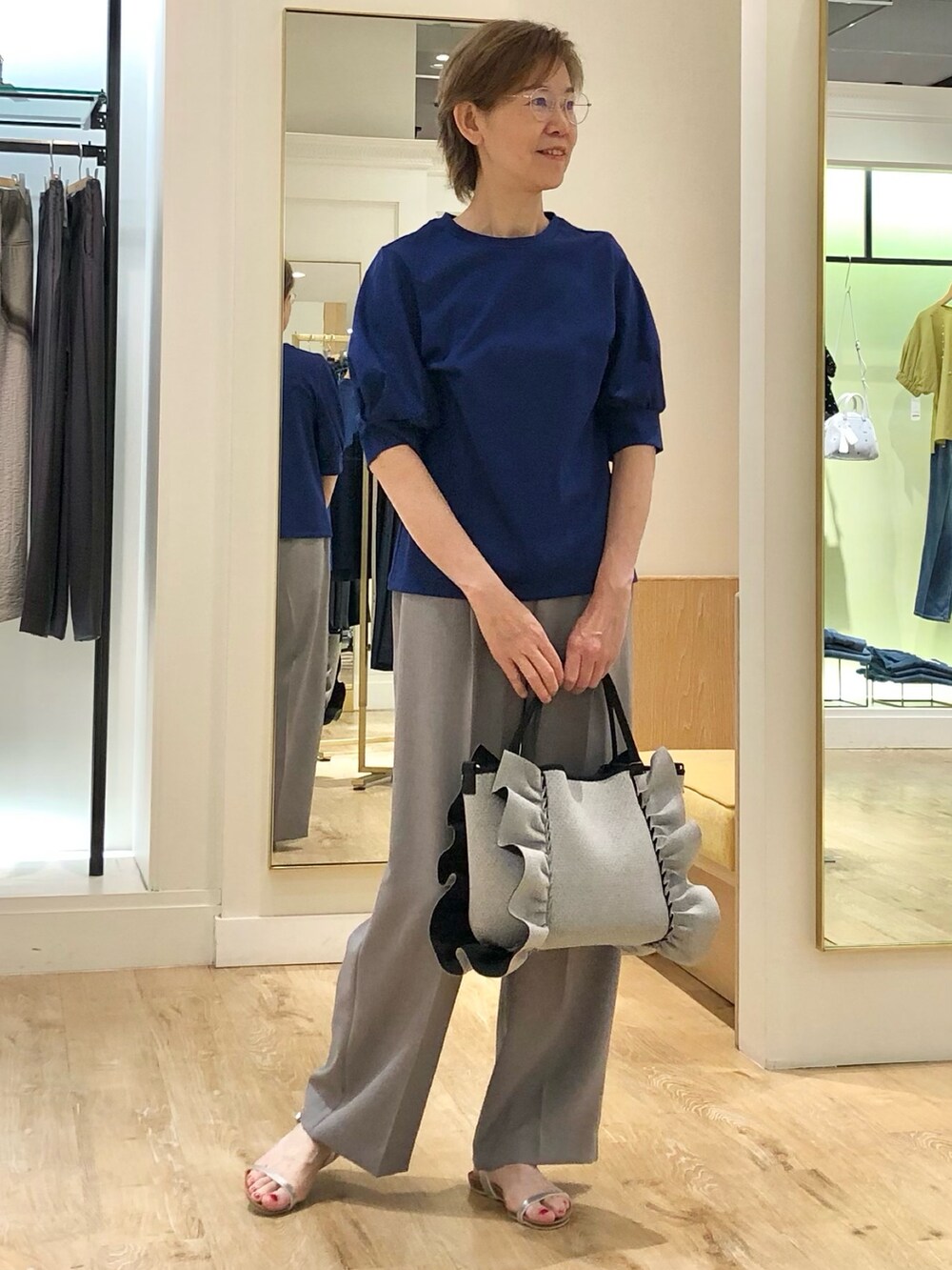 グレー系のその他パンツ、ブルー系のTシャツ/カットソー、グレー系のトートバッグを着用したレディースの夏コーディネートの2枚目の写真