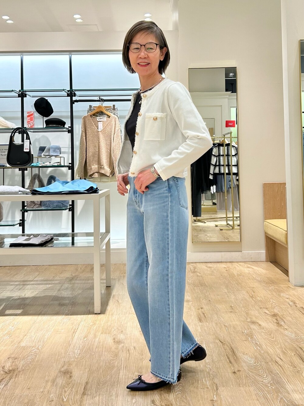 ブルー系のデニムパンツ、ホワイト系のカーディガン/ボレロ、グレー系のTシャツ/カットソーを着用したレディースの冬コーディネートの7枚目の写真