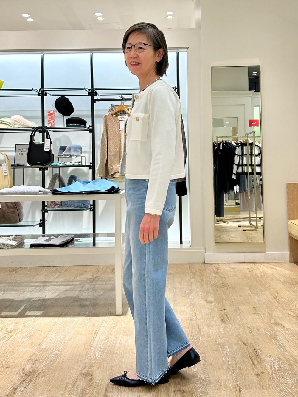 ブルー系のデニムパンツ、ホワイト系のカーディガン/ボレロ、グレー系のTシャツ/カットソーを着用したレディースの冬コーディネートの6枚目の写真