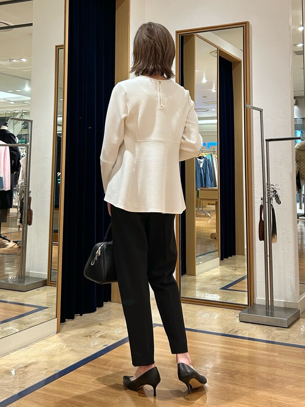 ブラック系のその他パンツ、ブラック系のショルダーバッグ、ホワイト系のTシャツ/カットソーを着用したレディースの冬コーディネートの3枚目の写真