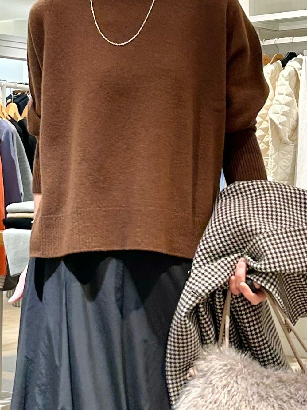 ブラック系のスカート、グレー系のショルダーバッグ、ベージュ系のチェスターコートを着用したレディースの冬コーディネートの6枚目の写真