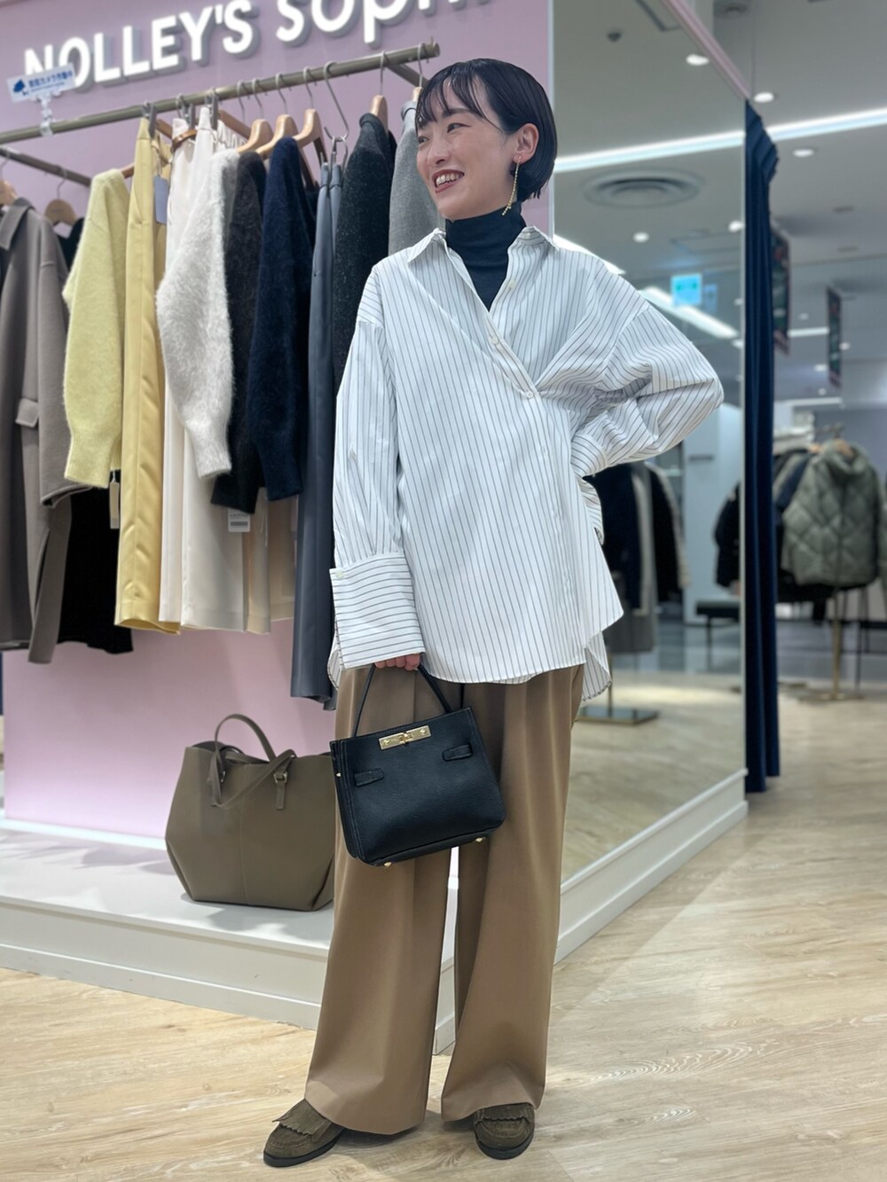 ホワイト系のシャツ/ブラウス、イエロー系のその他パンツ、ブラック系のショルダーバッグを着用したレディースの秋コーディネートの2枚目の写真