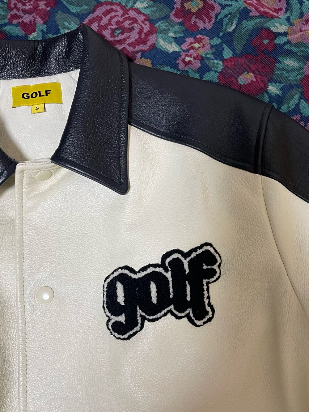 ホワイト系のスタジャン、ブラック系のパンツ、ブラック系のローファーを着用したレディースの冬コーディネートの2枚目の写真