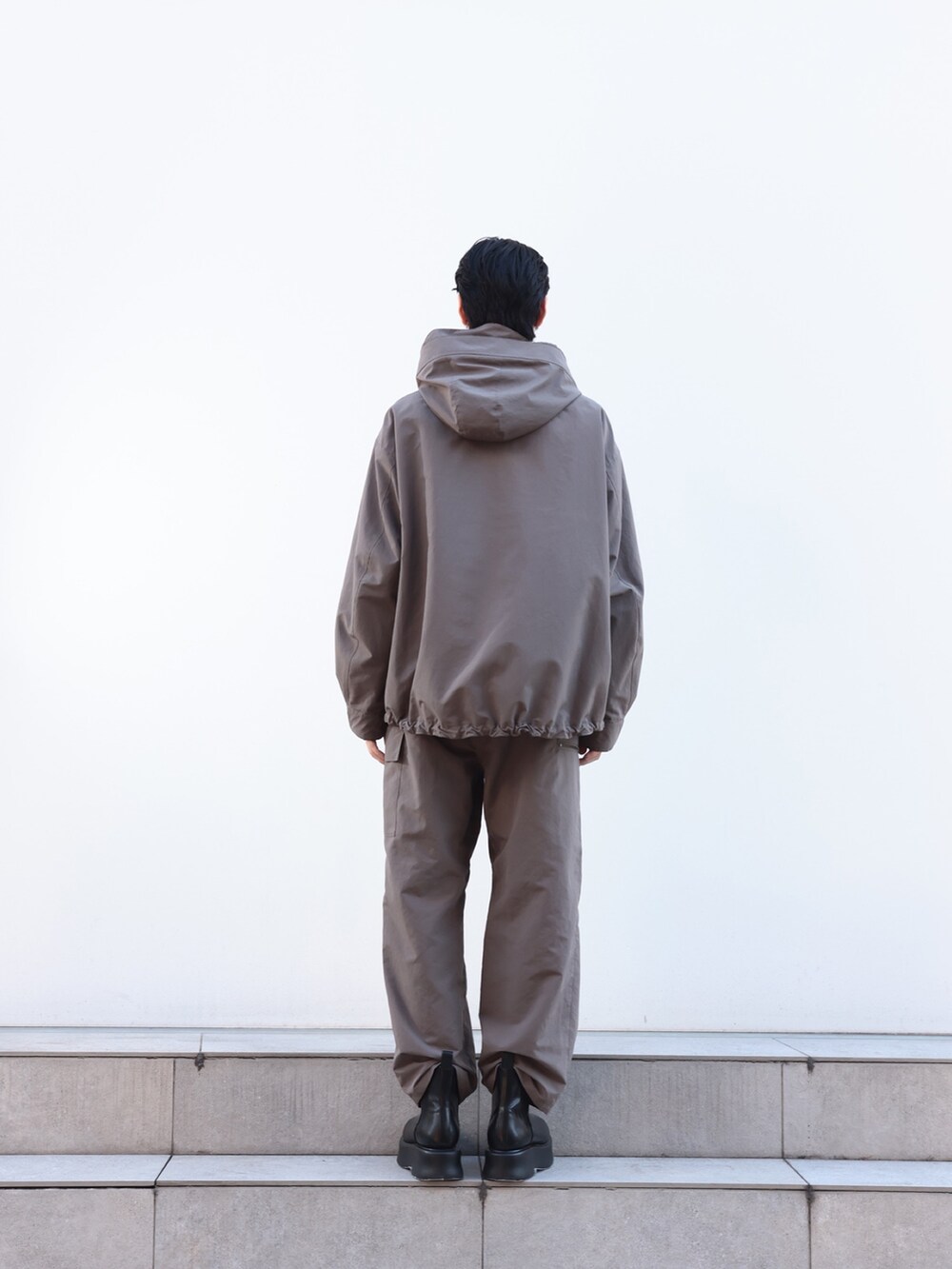 グレー系のカーゴパンツ、ブルー系のニット/セーター、グレー系のブルゾンを着用したメンズの冬コーディネートの4枚目の写真