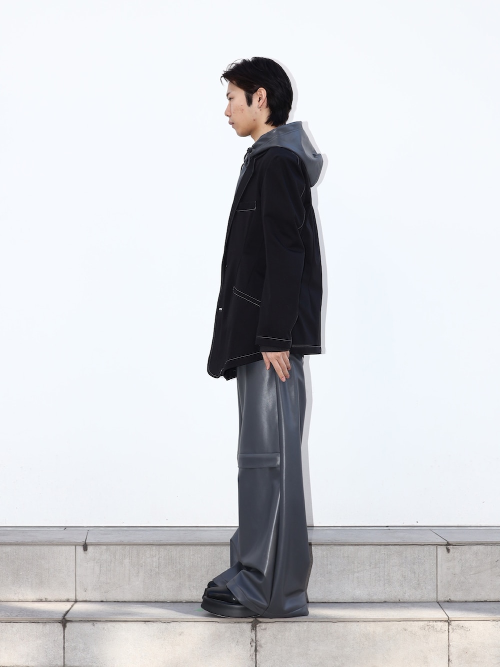 グレー系のその他パンツ、ブラック系のテーラードジャケットを着用したメンズの冬コーディネートの2枚目の写真