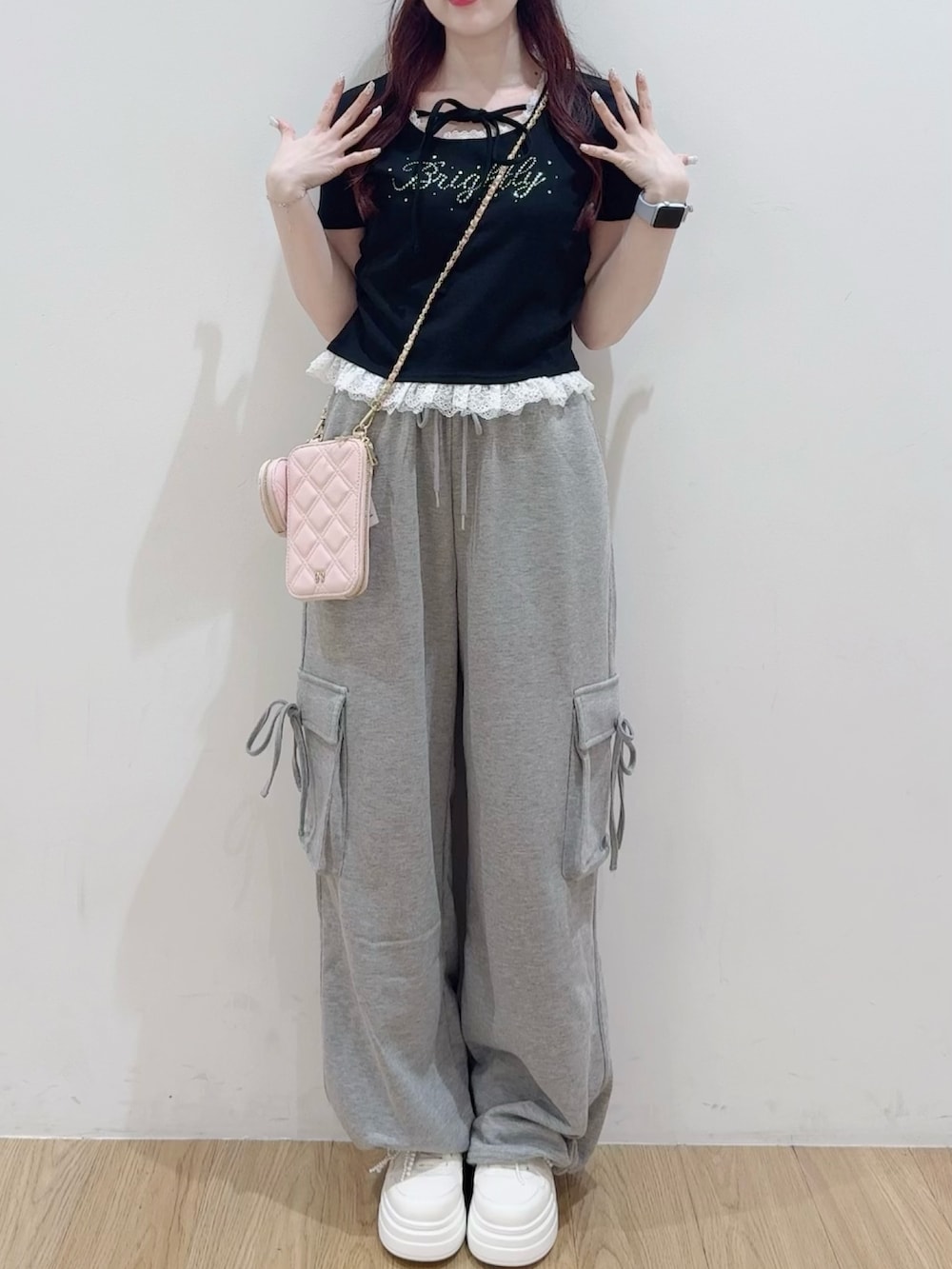 ブラック系のTシャツ/カットソー、ピンク系のショルダーバッグ、グレー系のカーゴパンツを着用したレディースの春コーディネートの2枚目の写真