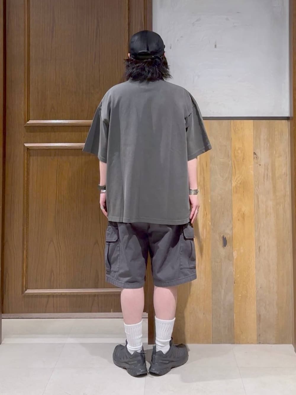 ブラック系のスニーカー、ブラック系のカーゴパンツ、ホワイト系のタンクトップを着用したメンズの春コーディネートの2枚目の写真