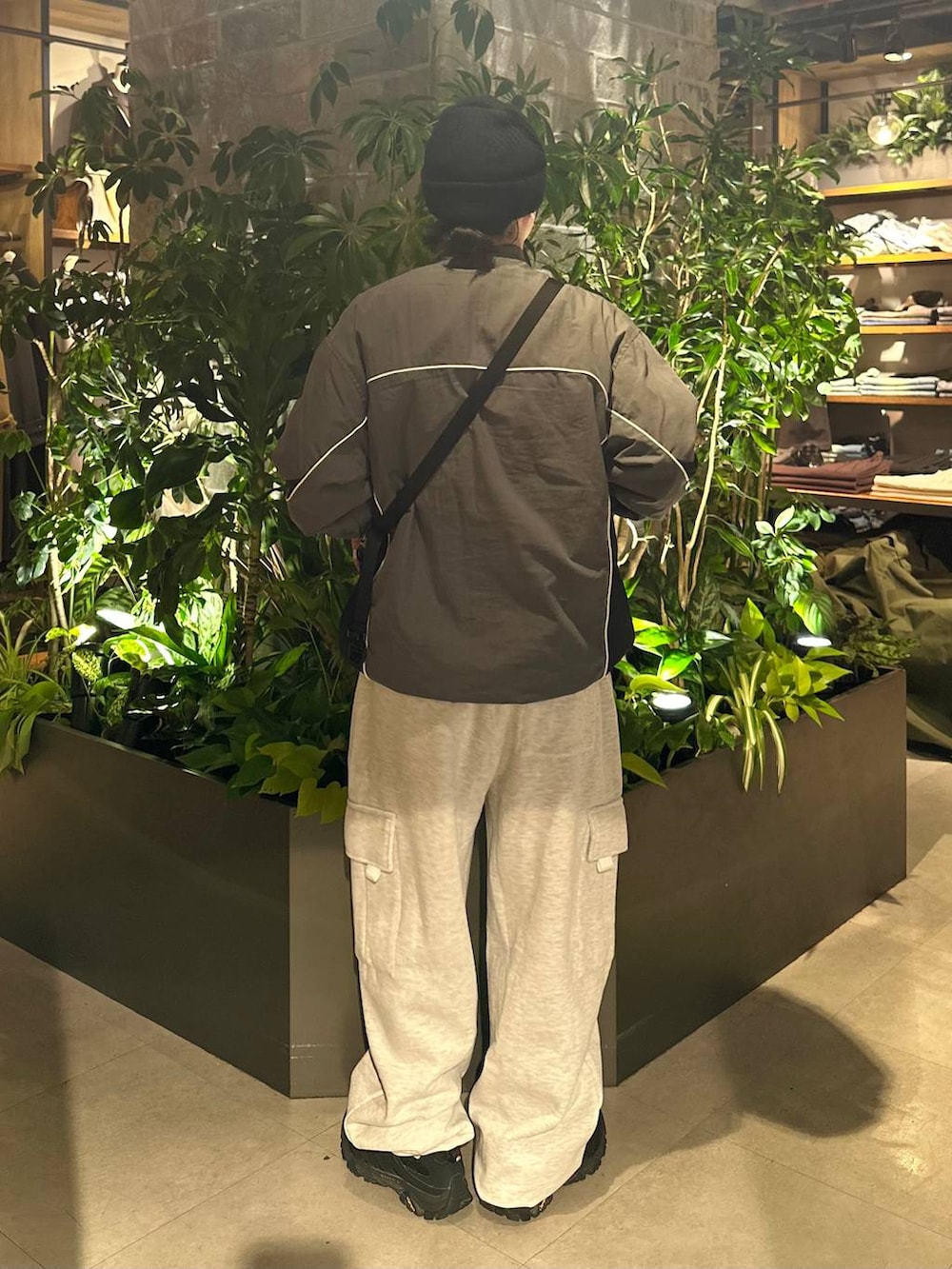 ブラック系のショルダーバッグ、ホワイト系のスウェットパンツ、グレー系のスウェットを着用したメンズの秋コーディネートの2枚目の写真