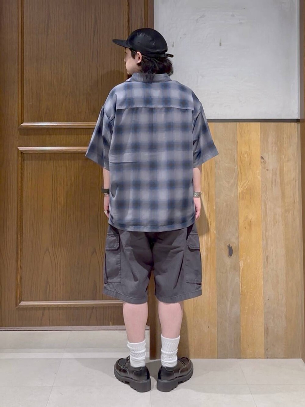 ブラック系のドレスシューズ、ブラック系のカーゴパンツ、ホワイト系のTシャツ/カットソーを着用したメンズの夏コーディネートの2枚目の写真