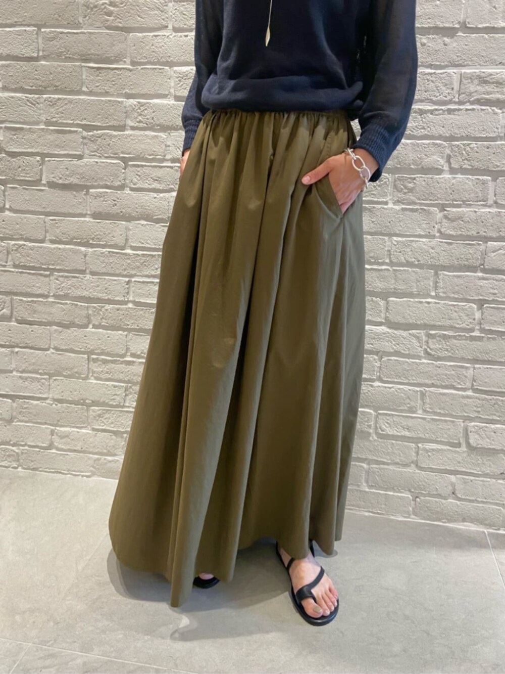 グリーン系のスカート、ブルー系のニット/セーターを着用したレディースの夏コーディネートの4枚目の写真