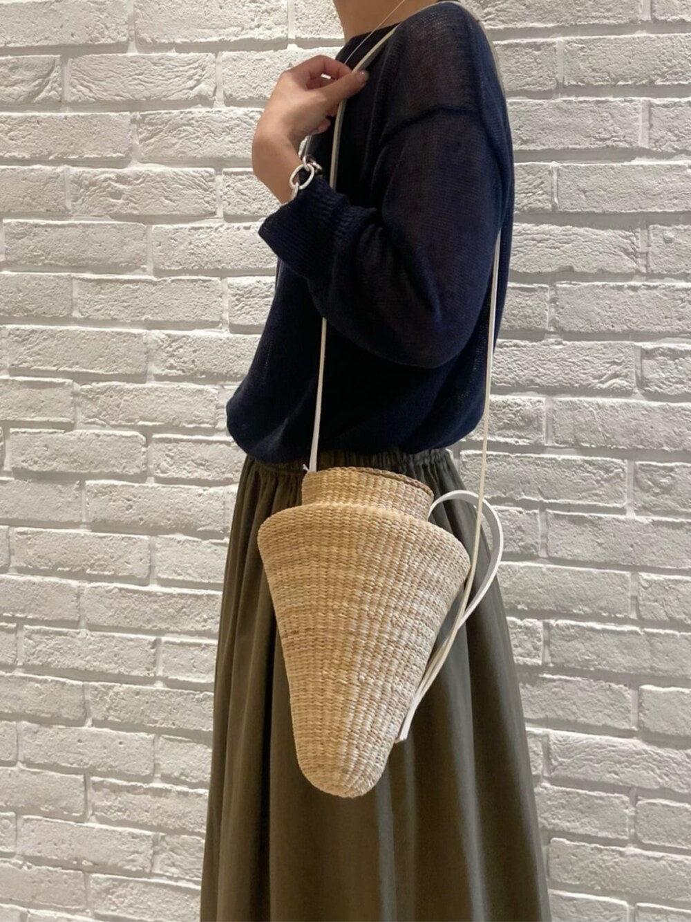 グリーン系のスカート、ブルー系のニット/セーターを着用したレディースの夏コーディネートの3枚目の写真