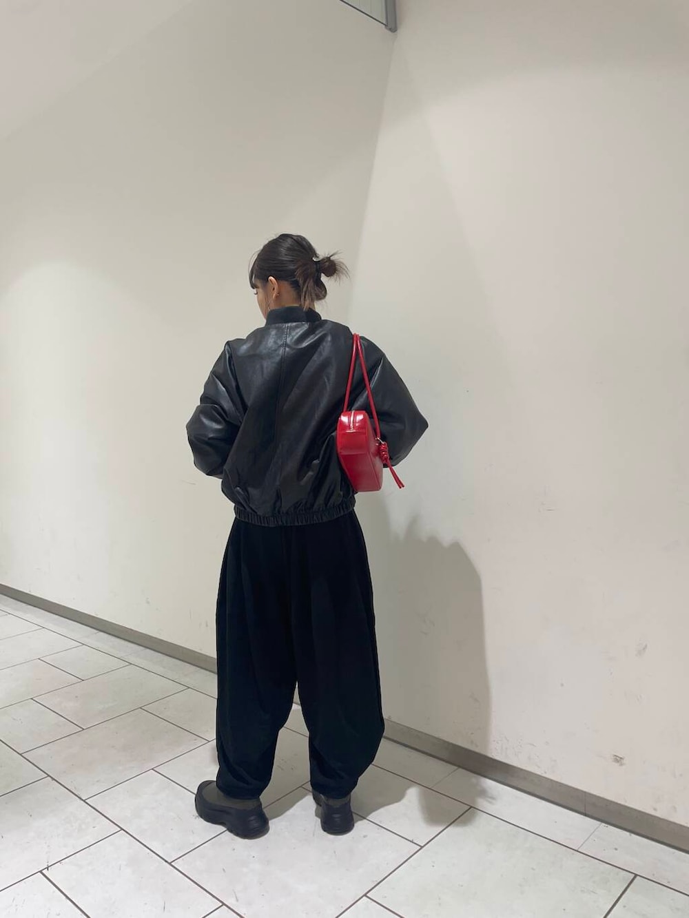 グリーン系のブーツ、ブラック系のその他パンツ、ブラック系のブルゾンを着用したレディースの秋コーディネートの3枚目の写真