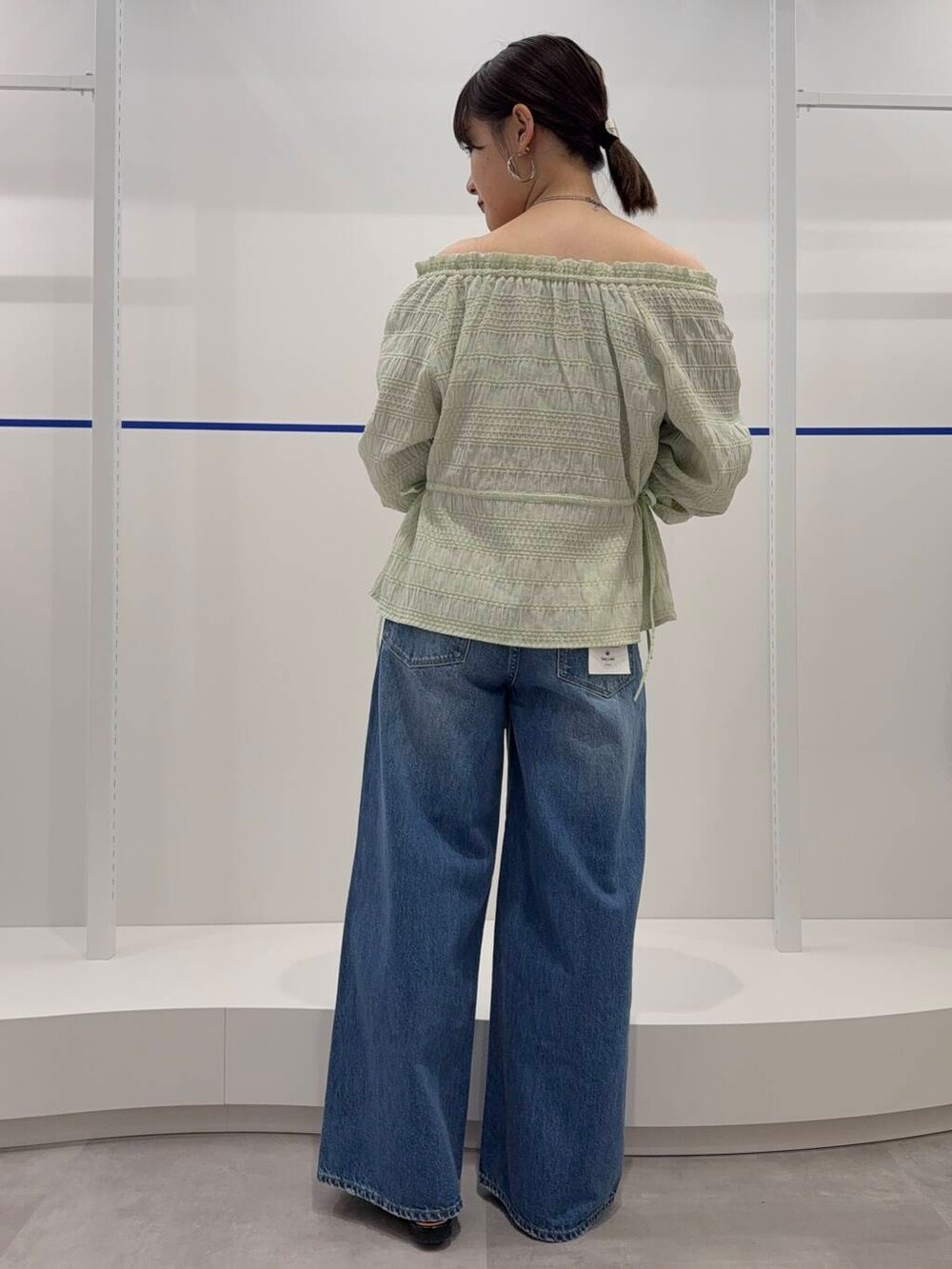 ブルー系のデニムパンツ、ブラック系のパンプス、グリーン系のシャツ/ブラウスを着用したレディースの春コーディネートの3枚目の写真