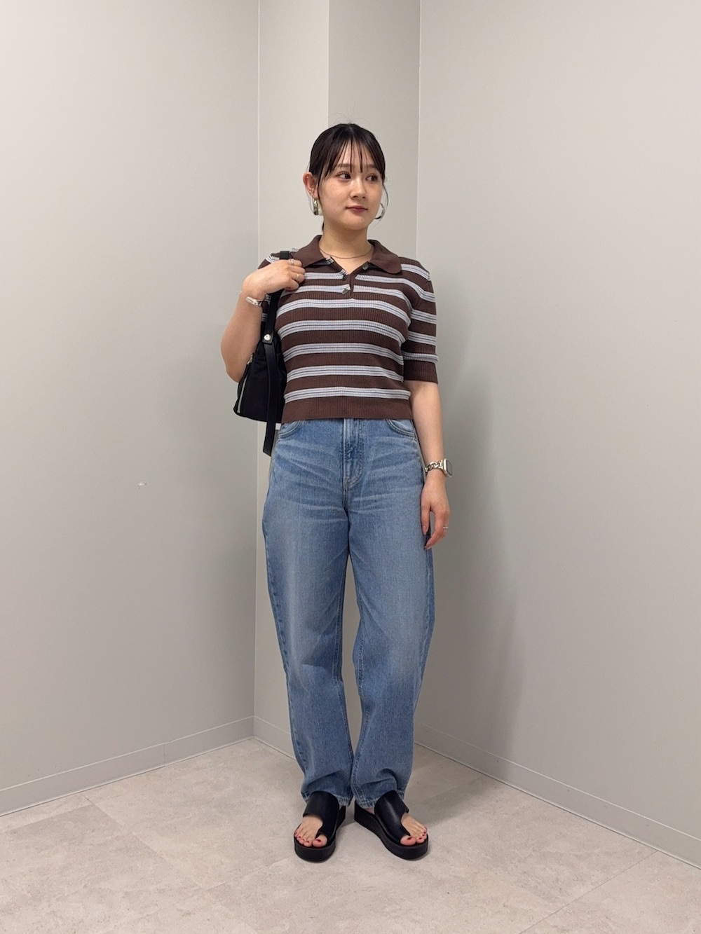 ブラウン系のニット/セーター、ブルー系のデニムパンツ、ブラック系のサンダルを着用したレディースの夏コーディネートの2枚目の写真