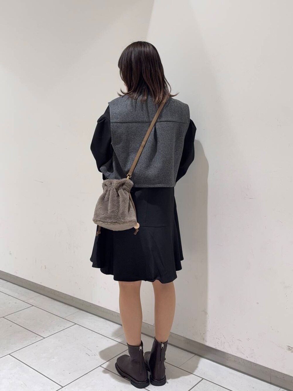 ブラウン系のブーツ、ブラウン系のショルダーバッグ、グレー系のその他アウターを着用したレディースの秋コーディネートの3枚目の写真