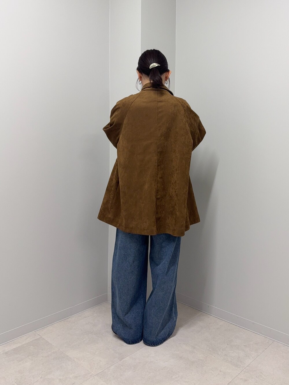 ブラウン系のカバーオール、ブルー系のデニムパンツ、ブラウン系のローファーを着用したレディースの秋コーディネートの4枚目の写真