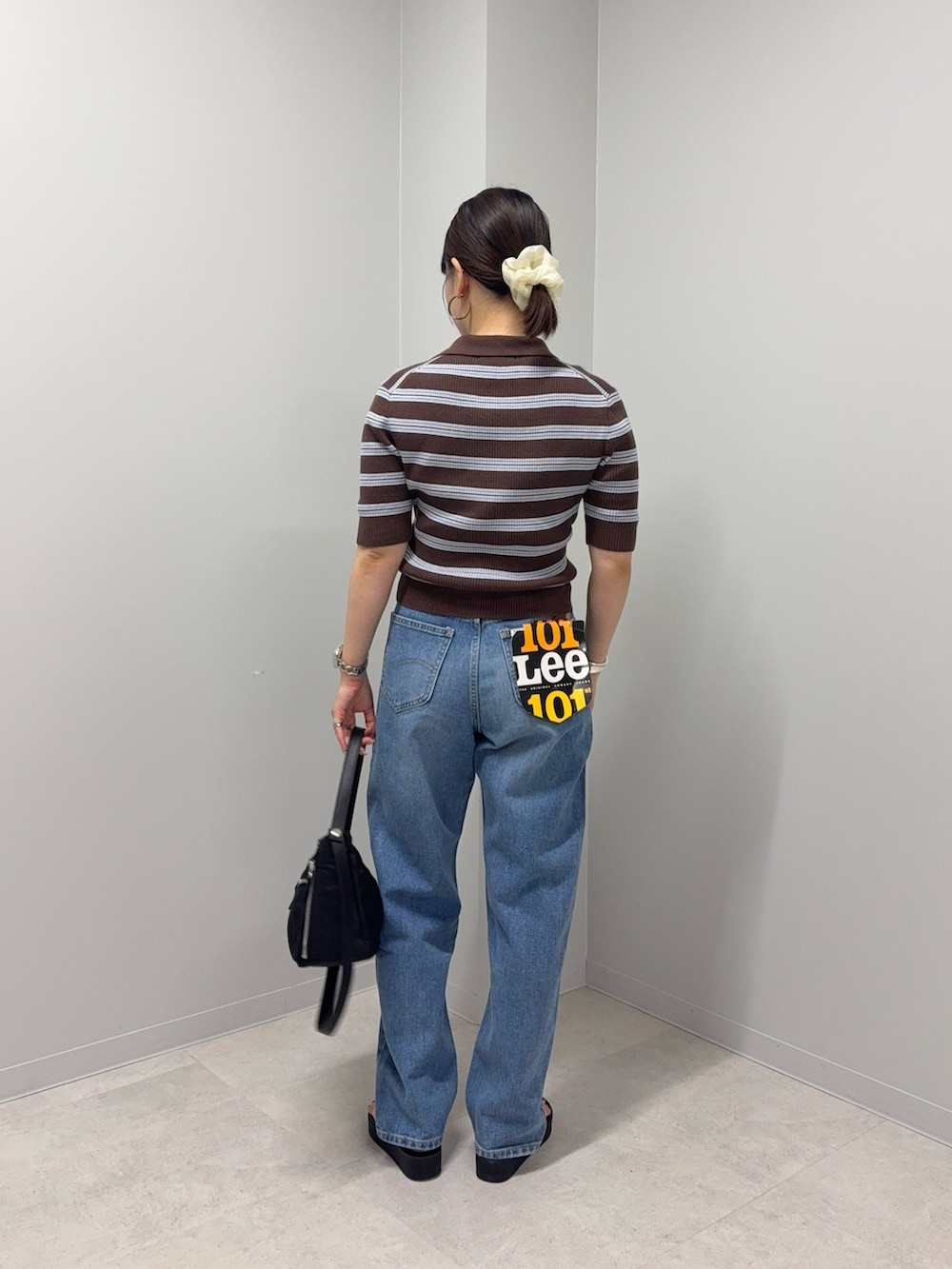 ブラウン系のニット/セーター、ブルー系のデニムパンツ、ブラック系のサンダルを着用したレディースの夏コーディネートの4枚目の写真