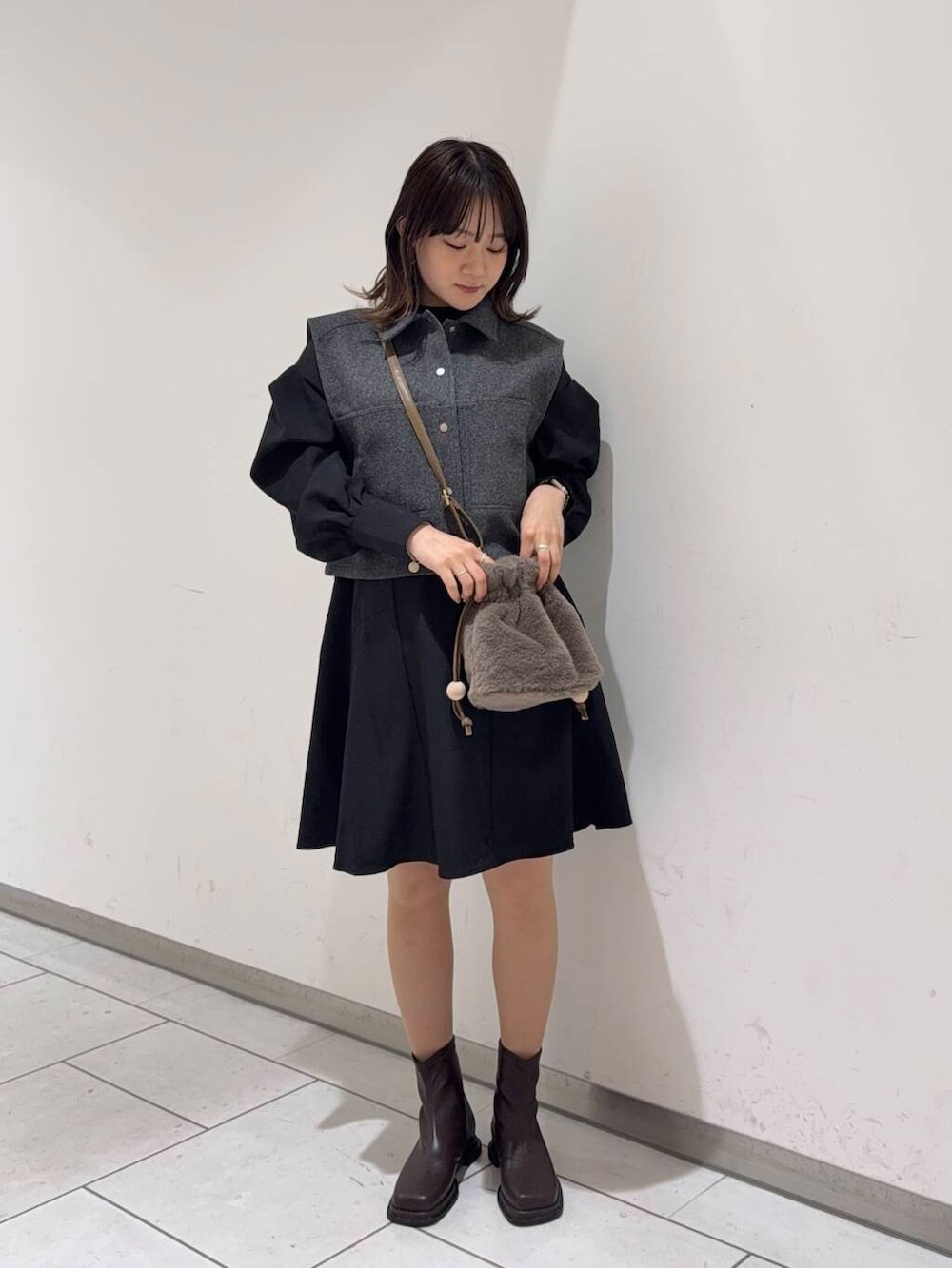 ブラウン系のブーツ、ブラウン系のショルダーバッグ、グレー系のその他アウターを着用したレディースの秋コーディネートの2枚目の写真