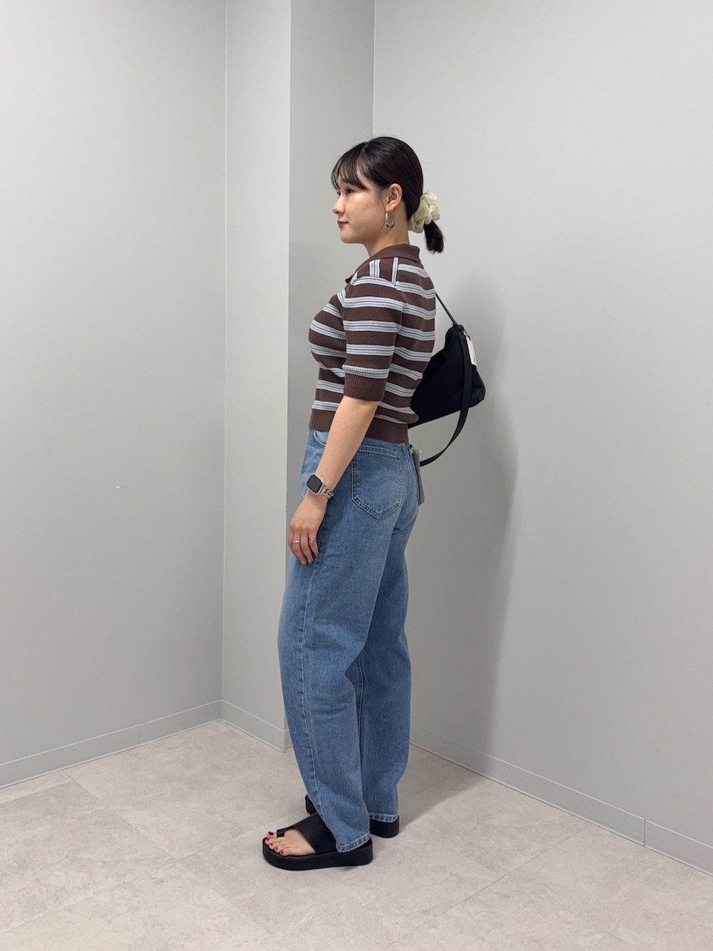 ブラウン系のニット/セーター、ブルー系のデニムパンツ、ブラック系のサンダルを着用したレディースの夏コーディネートの3枚目の写真