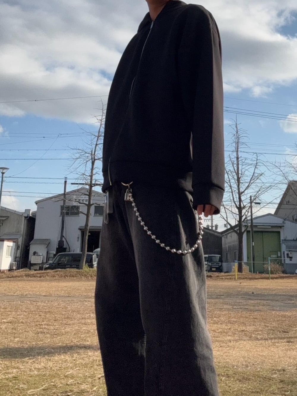 ブラック系のデニムパンツ、グリーン系のスニーカー、シルバー系のウォレットチェーンを着用したメンズの冬コーディネートの2枚目の写真