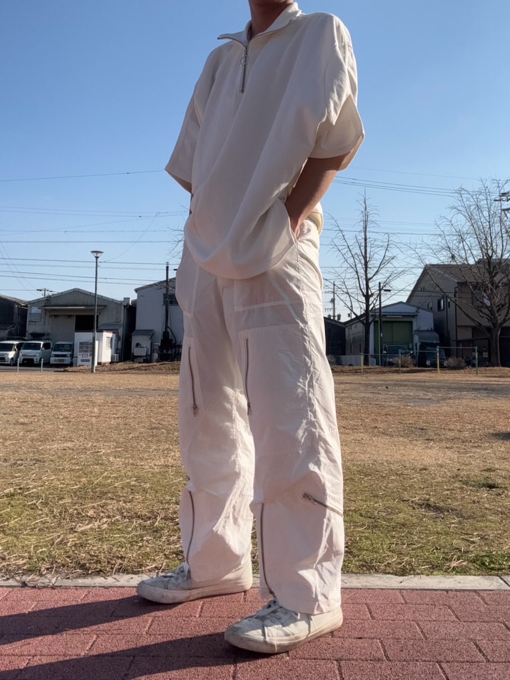 ホワイト系のスニーカー、ホワイト系のカーゴパンツ、ホワイト系のTシャツ/カットソーを着用したメンズの冬コーディネートの4枚目の写真