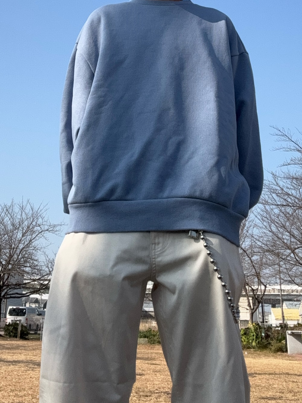 その他のチノパンツ、ブルー系のスウェットを着用したメンズの冬コーディネートの2枚目の写真