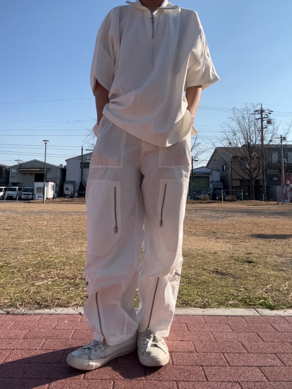 ホワイト系のスニーカー、ホワイト系のカーゴパンツ、ホワイト系のTシャツ/カットソーを着用したメンズの冬コーディネートの2枚目の写真