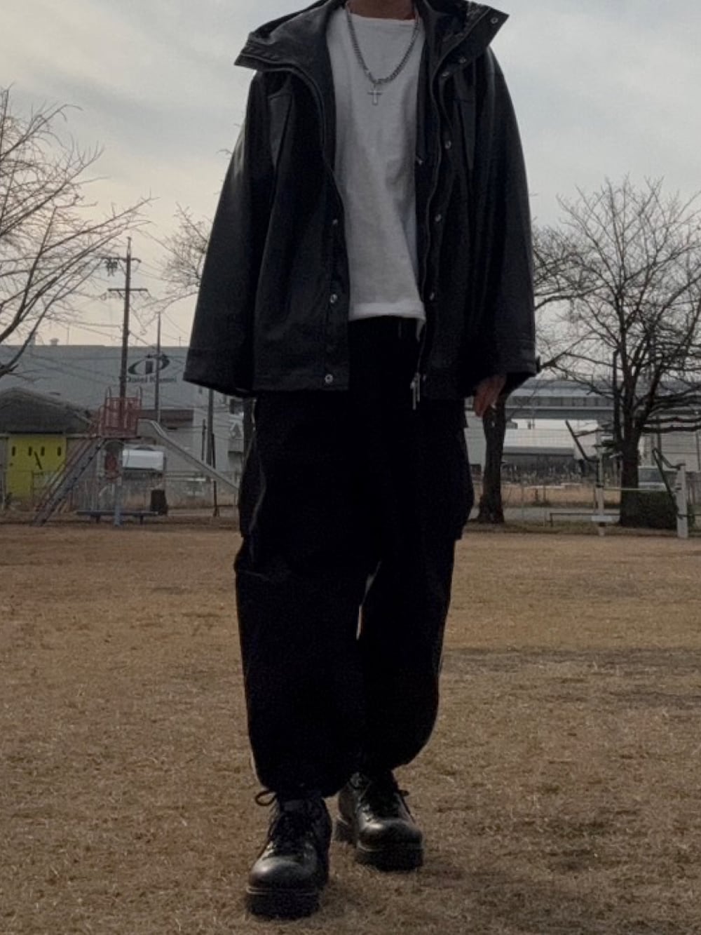 ブラック系のマウンテンパーカー、ホワイト系のTシャツ/カットソー、ホワイト系のカーゴパンツを着用したメンズの冬コーディネートの4枚目の写真