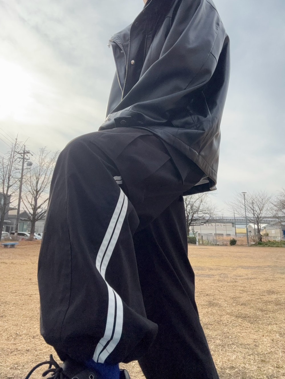 ブラック系のマウンテンパーカー、ホワイト系のTシャツ/カットソー、ホワイト系のカーゴパンツを着用したメンズの冬コーディネートの2枚目の写真