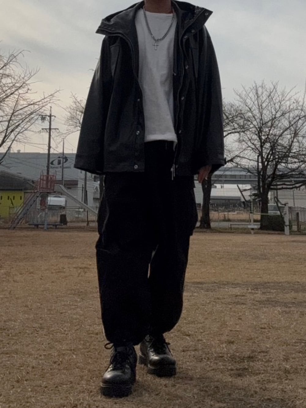 ブラック系のマウンテンパーカー、ホワイト系のTシャツ/カットソー、ホワイト系のカーゴパンツを着用したメンズの冬コーディネートの3枚目の写真