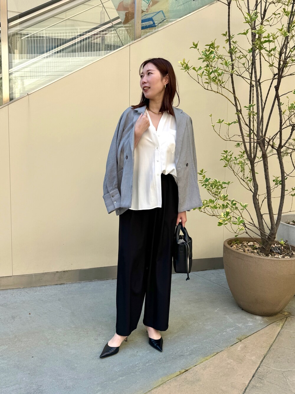 ブラック系のその他パンツ、ホワイト系のシャツ/ブラウス、グレー系のテーラードジャケットを着用したレディースの春コーディネートの5枚目の写真