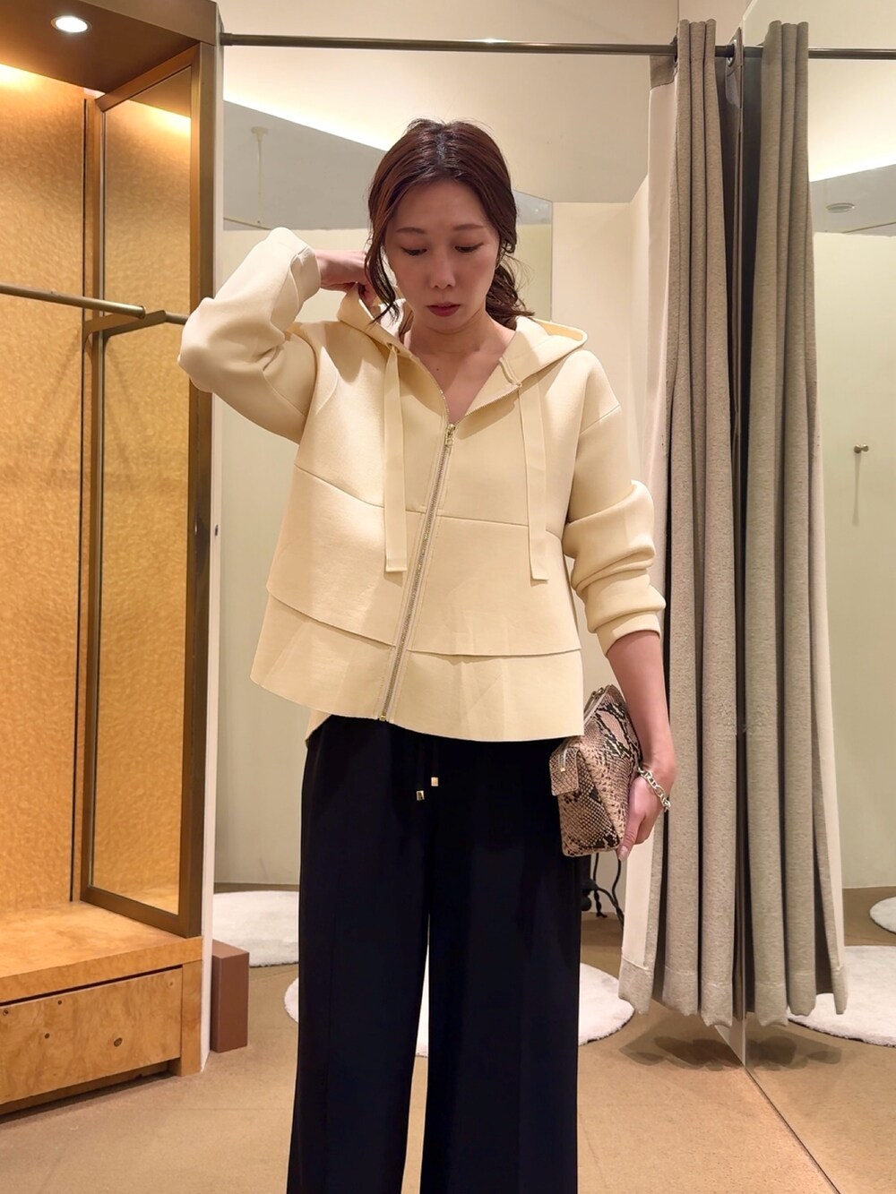 ホワイト系のパーカー、ブラック系のその他パンツを着用したレディースの冬コーディネートの4枚目の写真