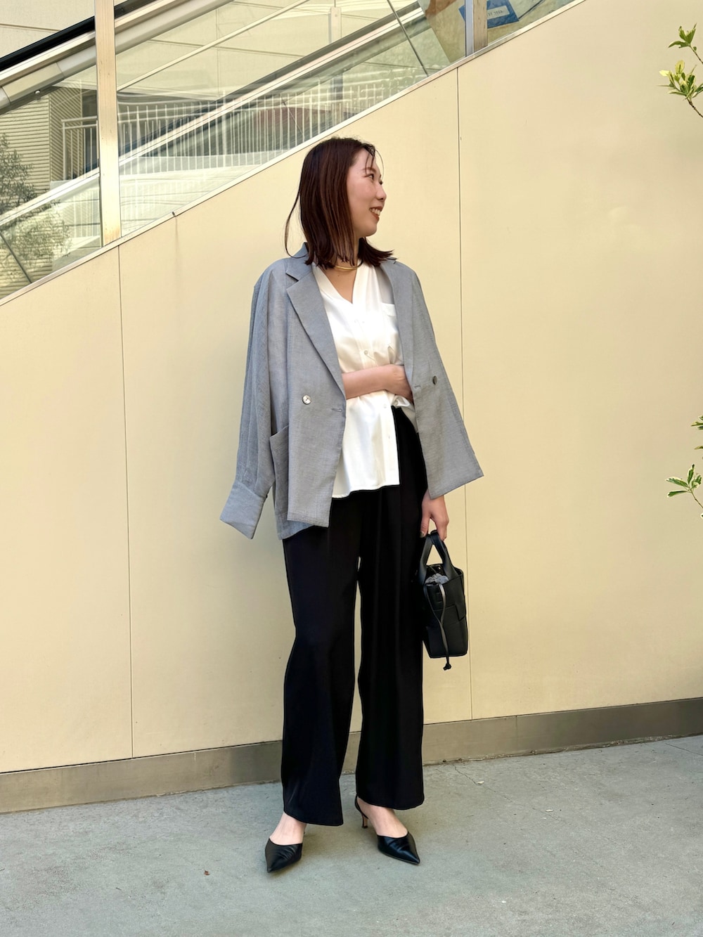 ブラック系のその他パンツ、ホワイト系のシャツ/ブラウス、グレー系のテーラードジャケットを着用したレディースの春コーディネートの2枚目の写真