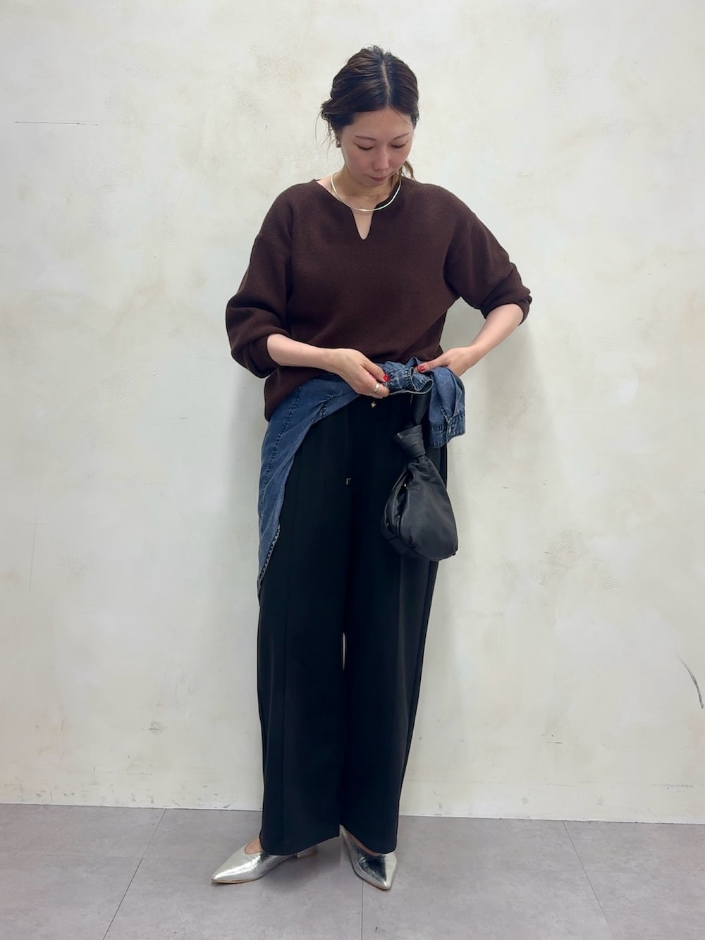 ブラウン系のニット/セーター、ブラック系のその他パンツ、ブルー系のシャツ/ブラウスを着用したレディースの夏コーディネートの2枚目の写真