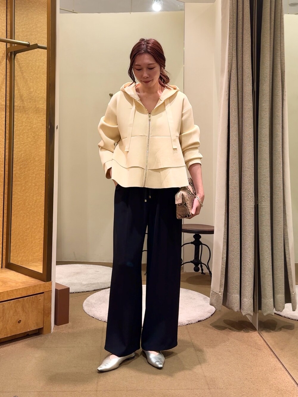 ホワイト系のパーカー、ブラック系のその他パンツを着用したレディースの冬コーディネートの2枚目の写真