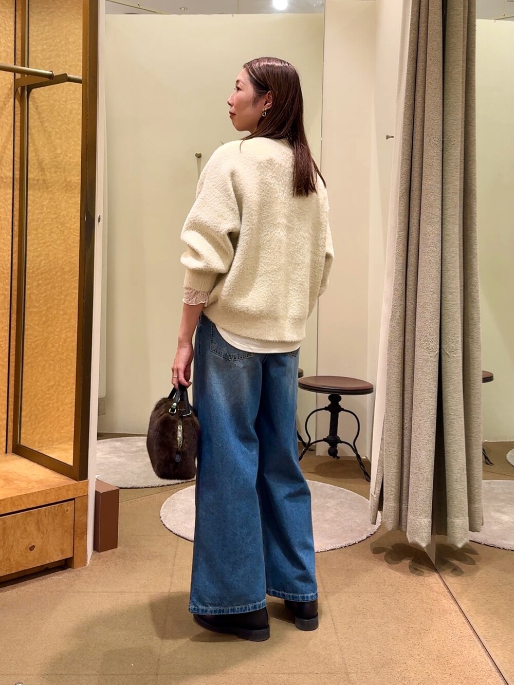 ホワイト系のニット/セーター、ホワイト系のTシャツ/カットソー、ブルー系のデニムパンツを着用したレディースの冬コーディネートの2枚目の写真