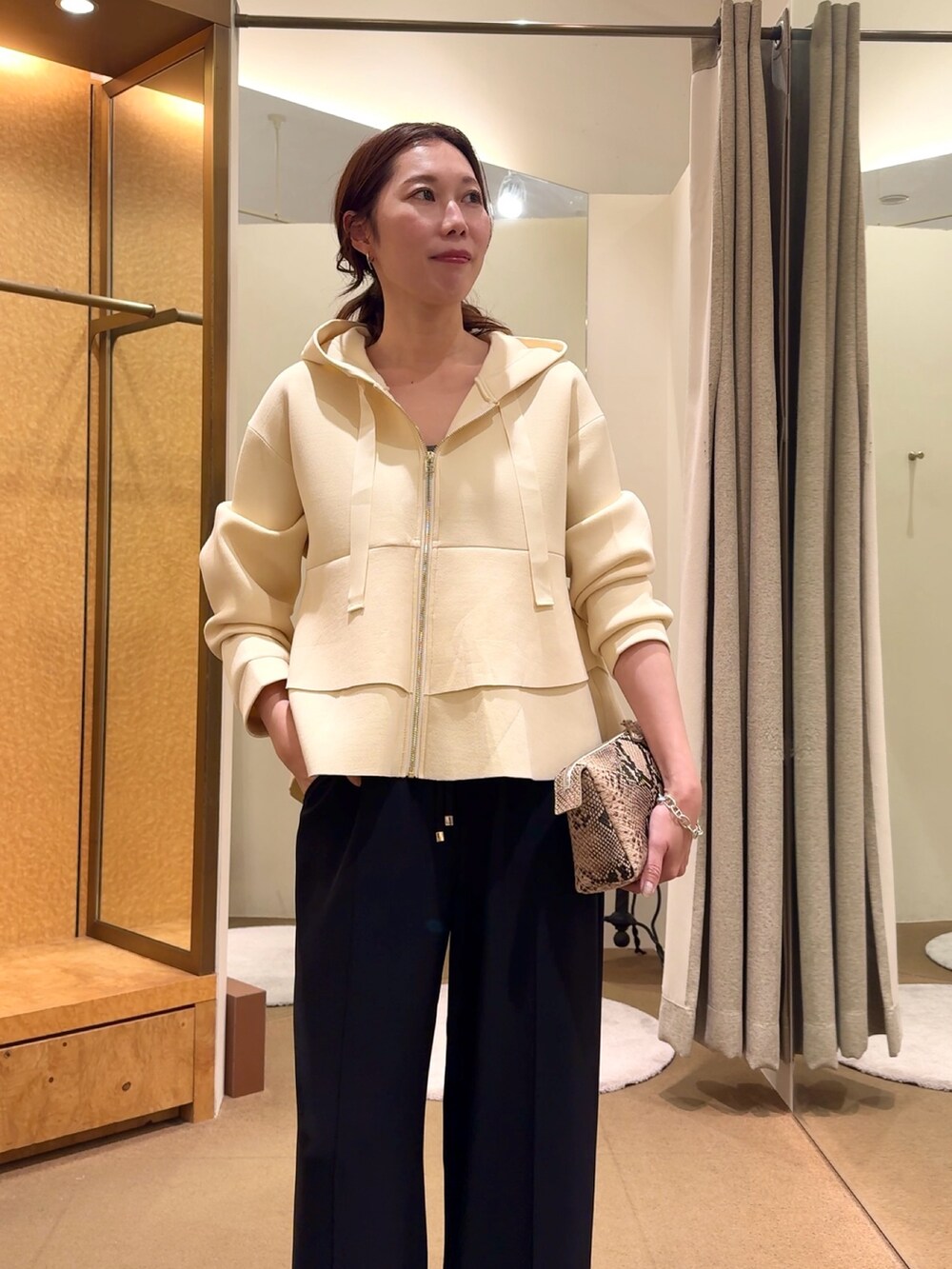 ホワイト系のパーカー、ブラック系のその他パンツを着用したレディースの冬コーディネートの3枚目の写真