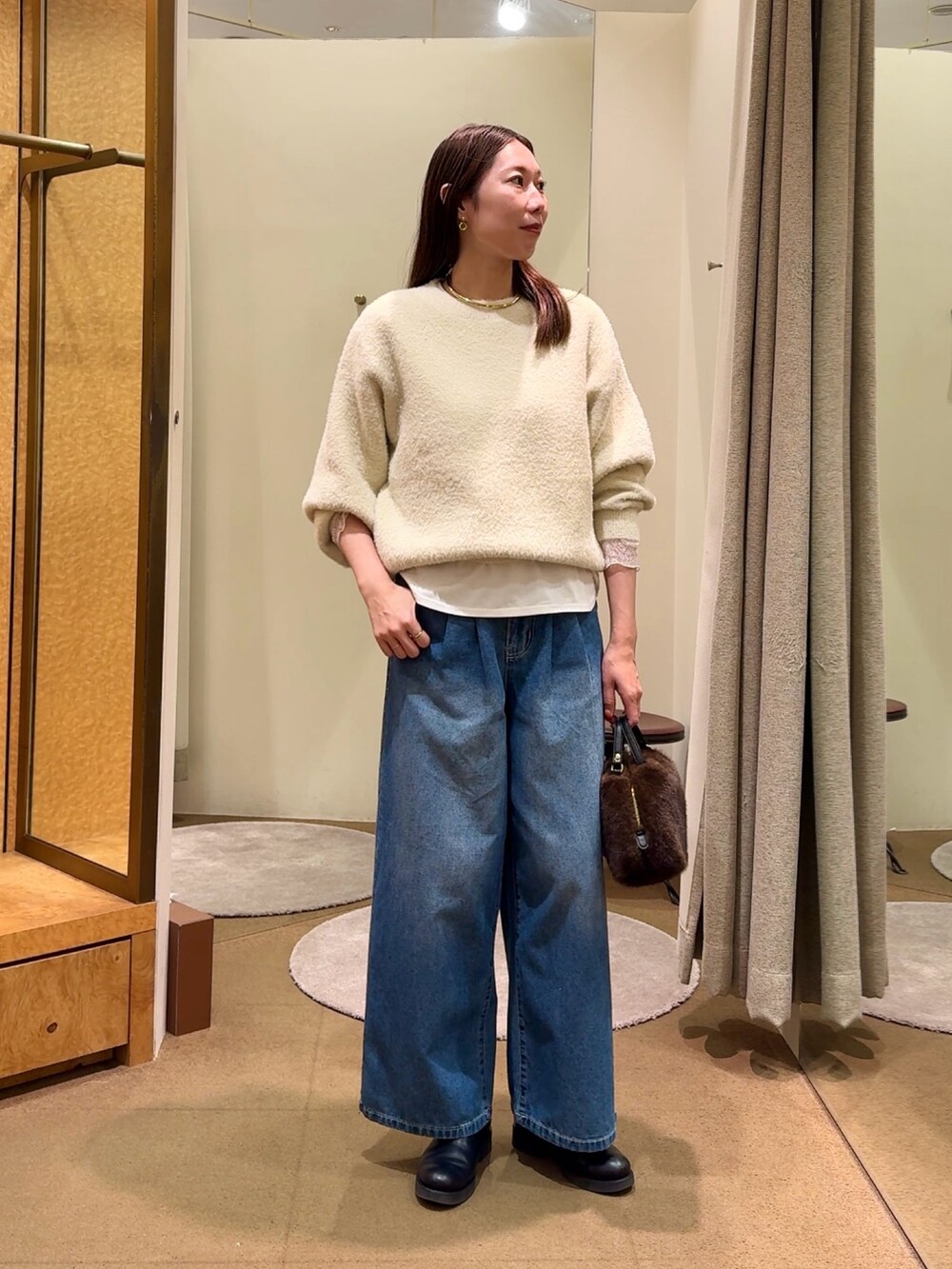 ホワイト系のニット/セーター、ホワイト系のTシャツ/カットソー、ブルー系のデニムパンツを着用したレディースの冬コーディネートの4枚目の写真
