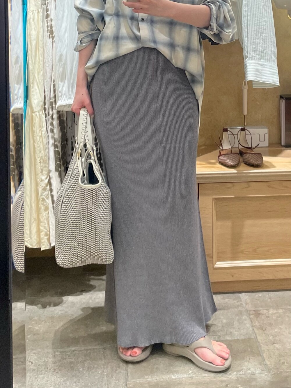 ベージュ系のシャツ/ブラウス、グレー系のスカート、ホワイト系のハンドバッグを着用したレディースの夏コーディネートの3枚目の写真