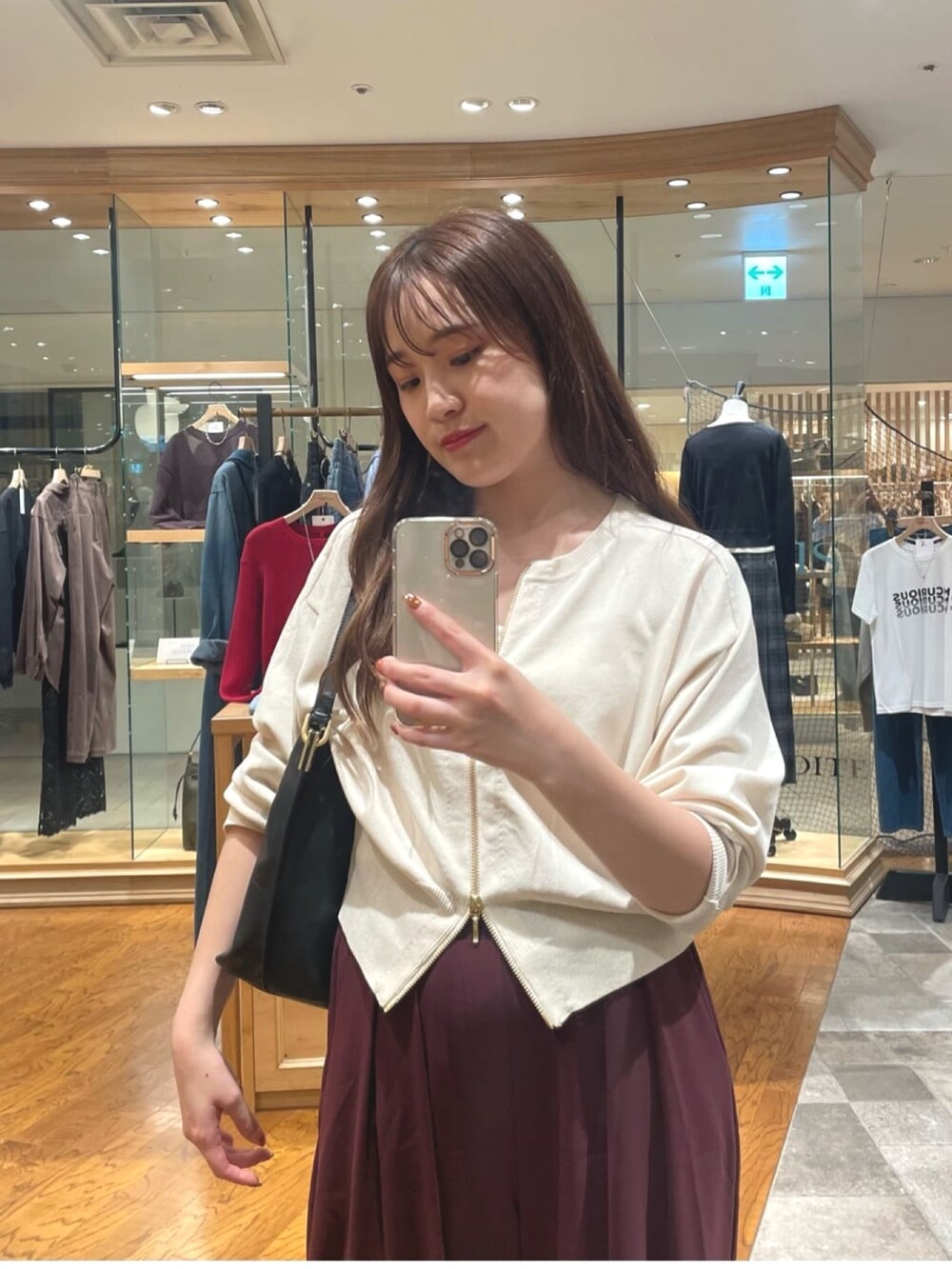 ホワイト系のカーディガン/ボレロ、レッド系のスラックス、ベージュ系のパンプスを着用したレディースの秋コーディネートの2枚目の写真