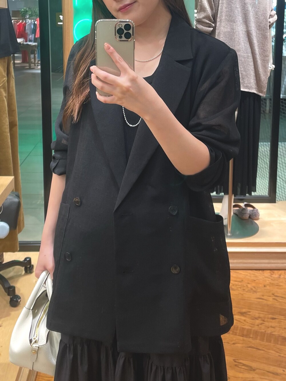 ブラウン系のワンピース、ブラック系のテーラードジャケット、シルバー系のネックレスを着用したレディースの夏コーディネートの2枚目の写真